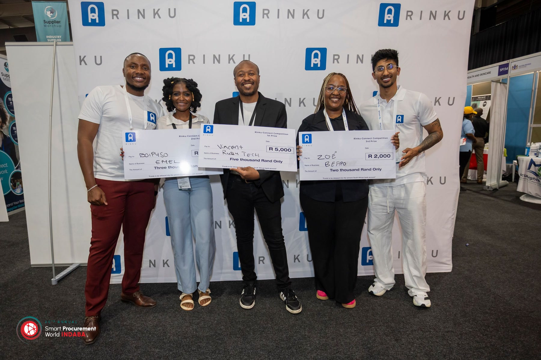 Gift Lubele with Rinku-Connect Competition winners holding novelty cheques at Smart Procurement World Indaba. Photograph.