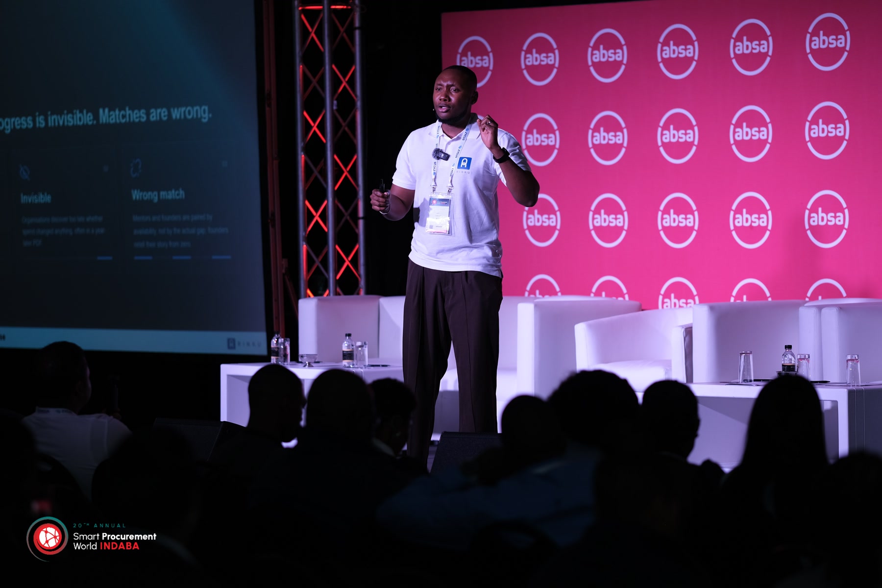 Gift Lubele gesturing on stage at Smart Procurement World Indaba, Absa branding behind him. Photograph.